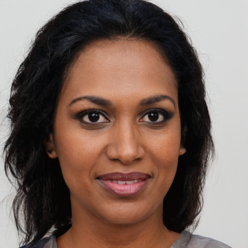 Joyful black young-adult female with medium  brown hair and brown eyes