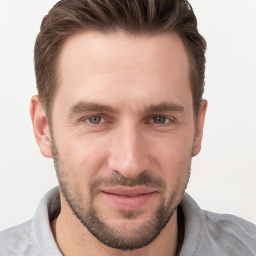 Joyful white young-adult male with short  brown hair and grey eyes