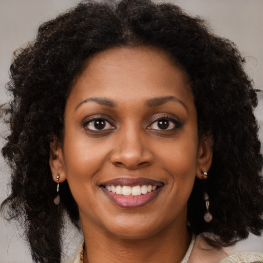 Joyful black young-adult female with medium  brown hair and brown eyes