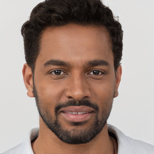 Joyful black young-adult male with short  brown hair and brown eyes