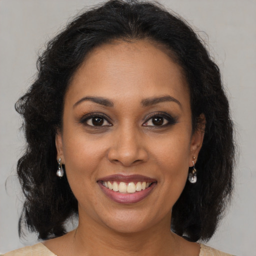 Joyful black young-adult female with medium  brown hair and brown eyes