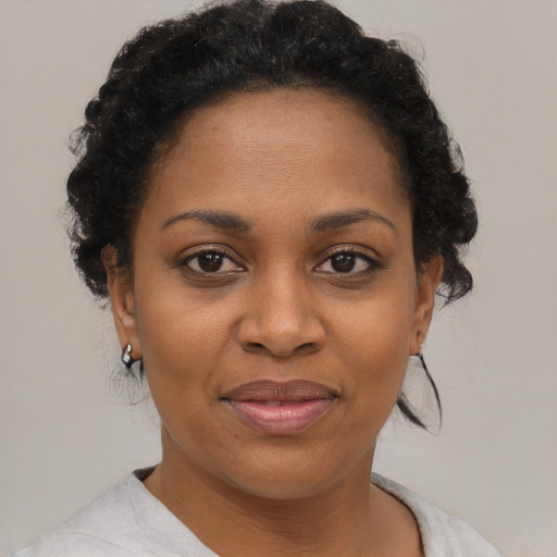 Joyful black adult female with short  brown hair and brown eyes