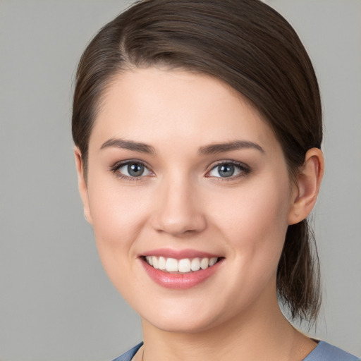 Joyful white young-adult female with medium  brown hair and grey eyes