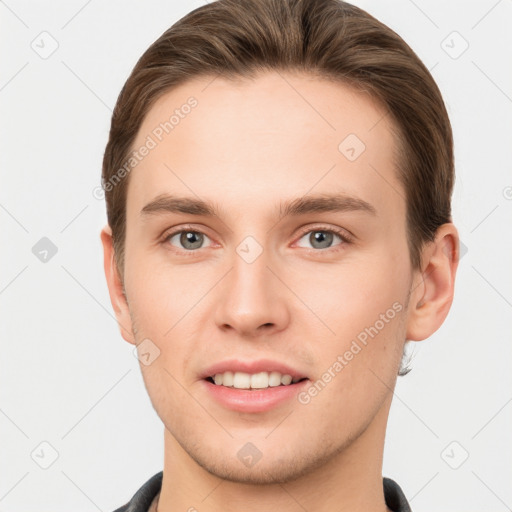 Joyful white young-adult male with short  brown hair and grey eyes