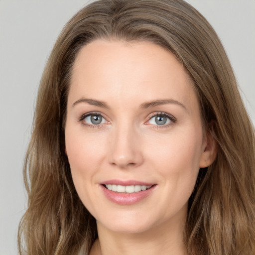 Joyful white young-adult female with long  brown hair and grey eyes