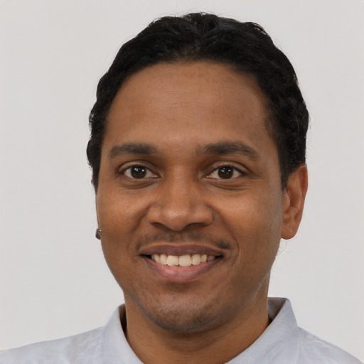 Joyful black young-adult male with short  black hair and brown eyes