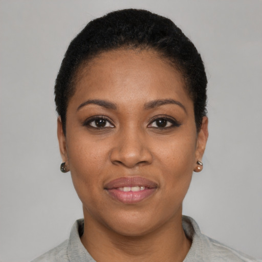 Joyful black young-adult female with short  black hair and brown eyes