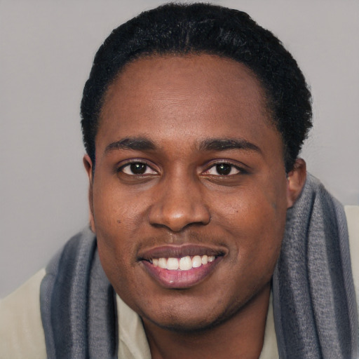 Joyful black young-adult male with short  black hair and brown eyes