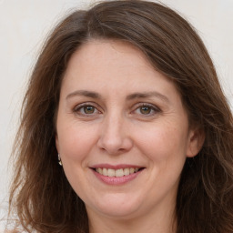 Joyful white adult female with long  brown hair and grey eyes