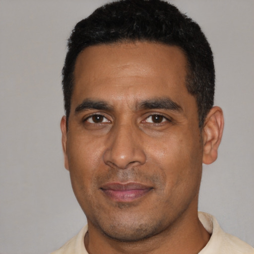 Joyful black young-adult male with short  black hair and brown eyes