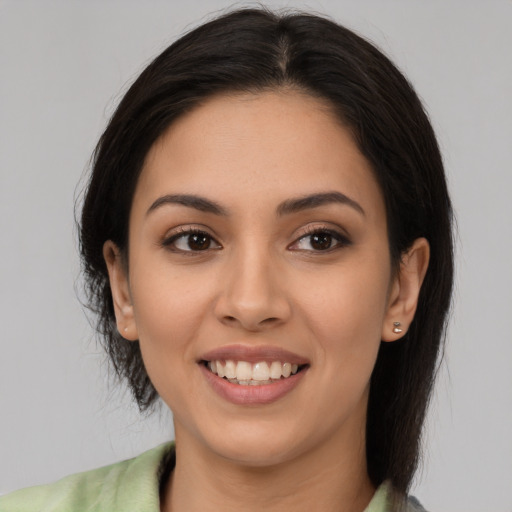 Joyful latino young-adult female with medium  brown hair and brown eyes