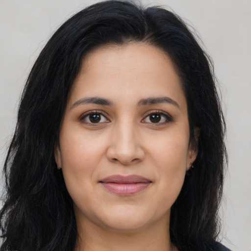 Joyful latino young-adult female with long  brown hair and brown eyes