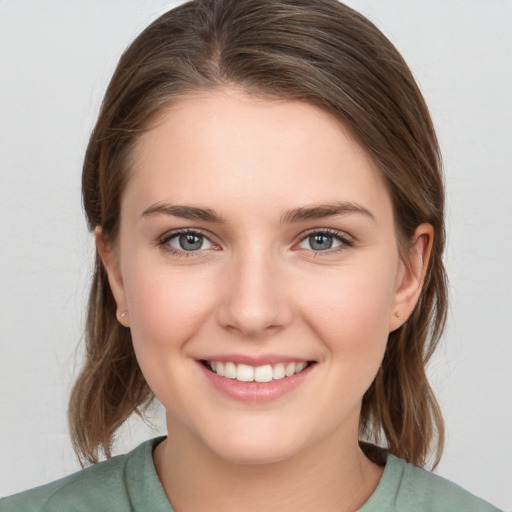 Joyful white young-adult female with medium  brown hair and grey eyes