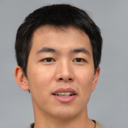 Joyful asian young-adult male with short  brown hair and brown eyes