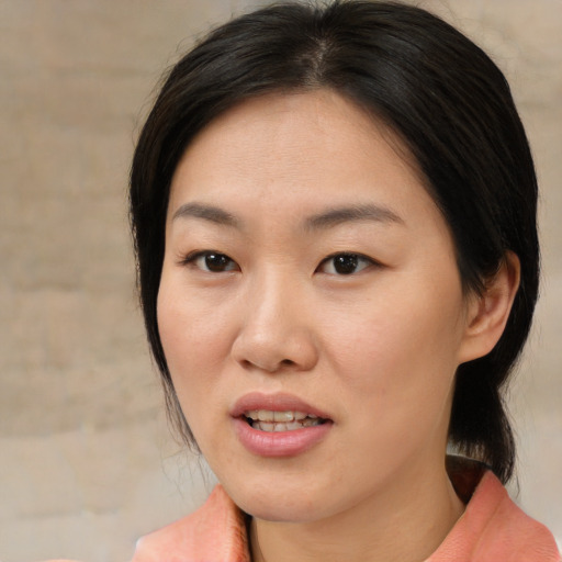 Joyful asian adult female with medium  brown hair and brown eyes