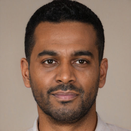 Joyful black young-adult male with short  black hair and brown eyes