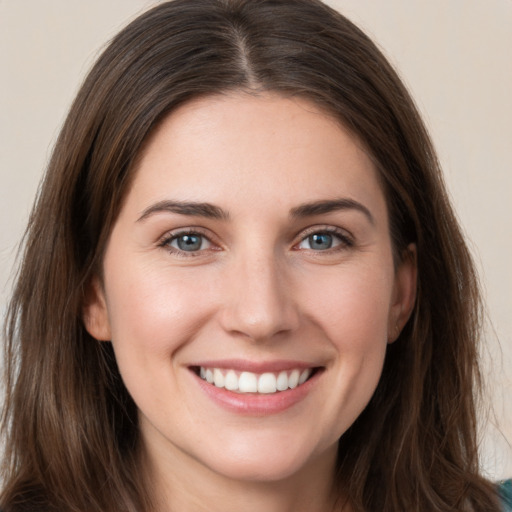 Joyful white young-adult female with long  brown hair and grey eyes