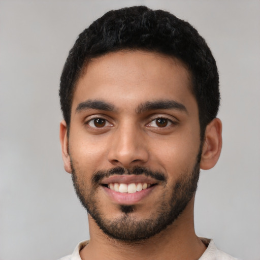 Joyful latino young-adult male with short  black hair and brown eyes