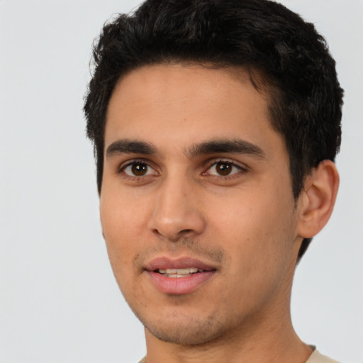 Joyful white young-adult male with short  black hair and brown eyes