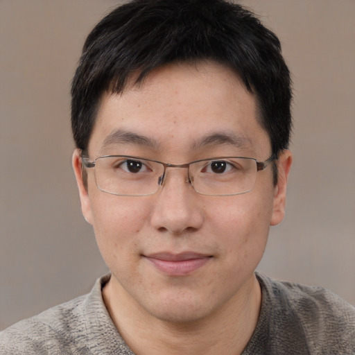 Joyful asian adult male with short  brown hair and brown eyes