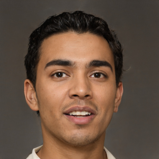 Joyful latino young-adult male with short  black hair and brown eyes