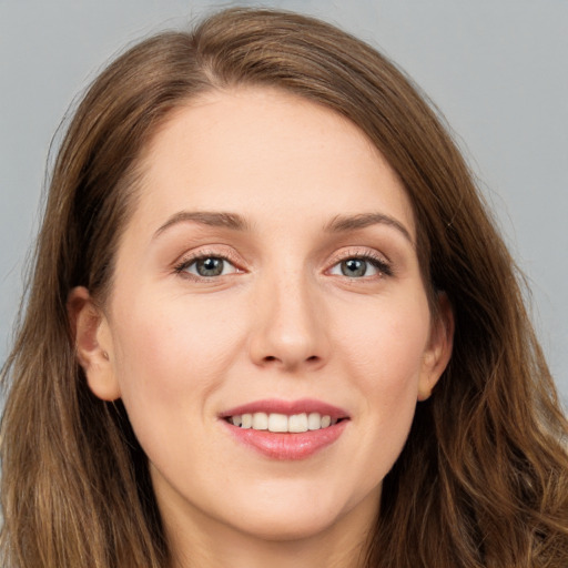 Joyful white young-adult female with long  brown hair and grey eyes