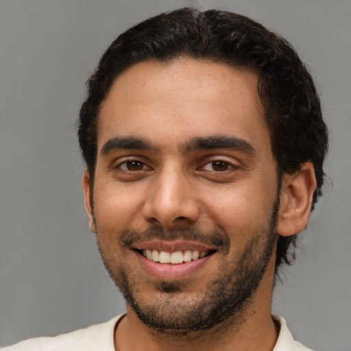 Joyful latino young-adult male with short  black hair and brown eyes