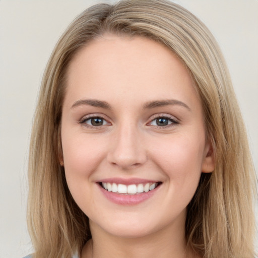 Joyful white young-adult female with long  brown hair and blue eyes