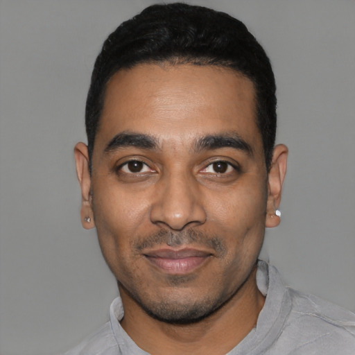 Joyful black young-adult male with short  black hair and brown eyes