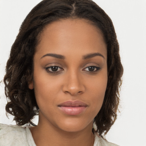 Joyful black young-adult female with long  brown hair and brown eyes