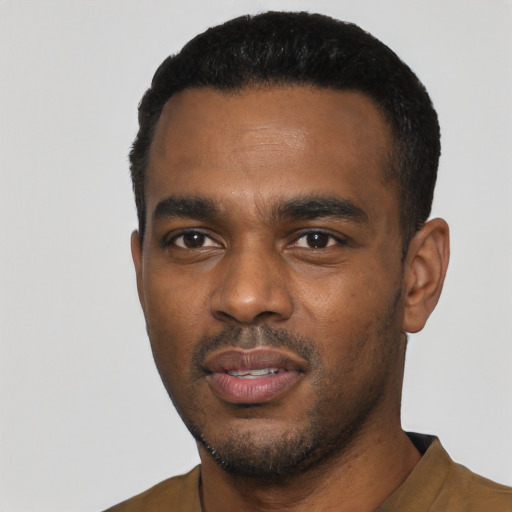 Joyful black young-adult male with short  black hair and brown eyes