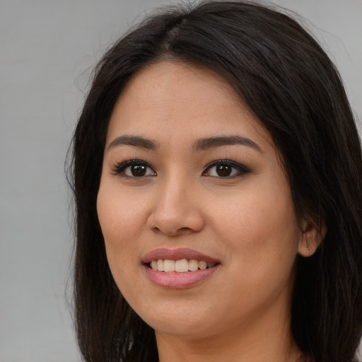 Joyful asian young-adult female with long  brown hair and brown eyes