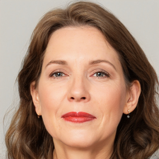 Joyful white adult female with long  brown hair and grey eyes