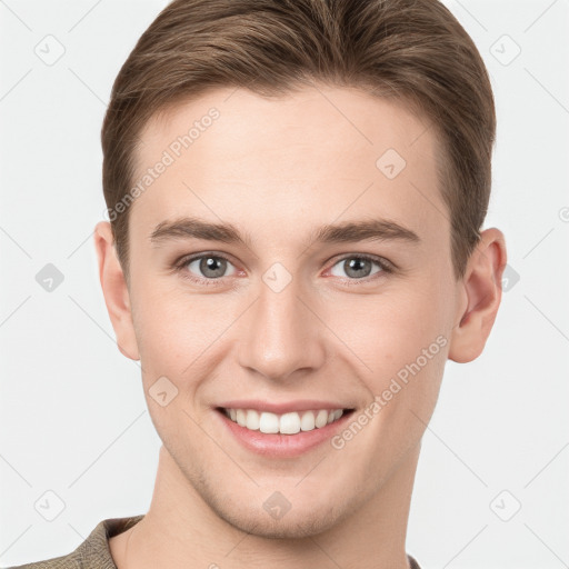 Joyful white young-adult male with short  brown hair and grey eyes