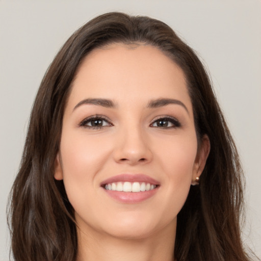 Joyful white young-adult female with long  brown hair and brown eyes