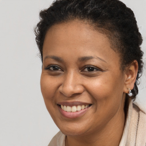 Joyful black young-adult female with short  brown hair and brown eyes