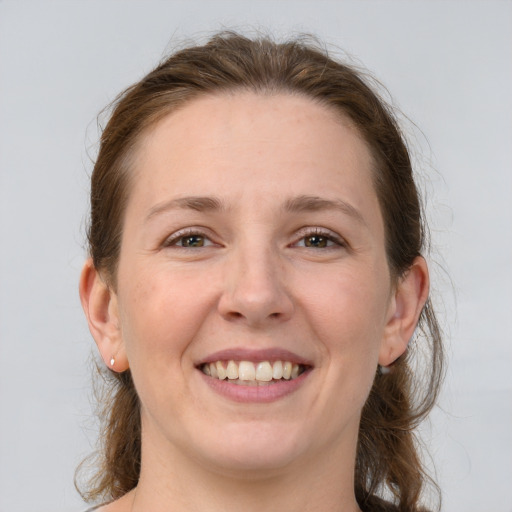 Joyful white adult female with medium  brown hair and grey eyes