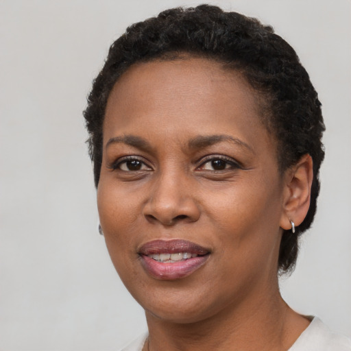 Joyful black adult female with short  brown hair and brown eyes