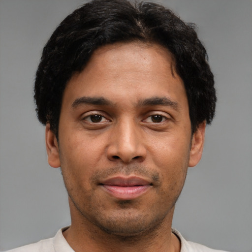 Joyful latino young-adult male with short  brown hair and brown eyes