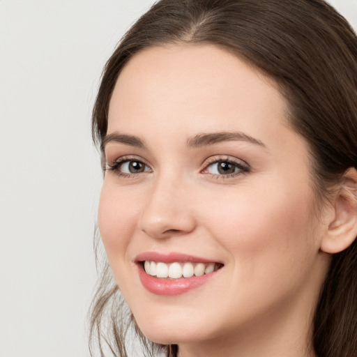 Joyful white young-adult female with long  brown hair and grey eyes