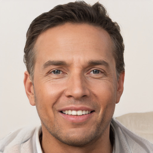 Joyful white adult male with short  brown hair and brown eyes