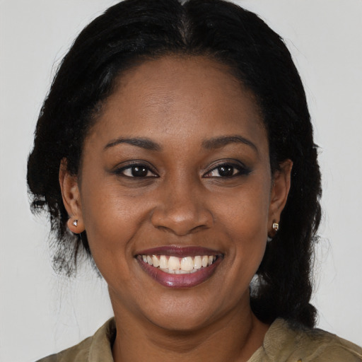 Joyful black young-adult female with long  black hair and brown eyes