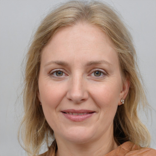 Joyful white adult female with medium  brown hair and blue eyes