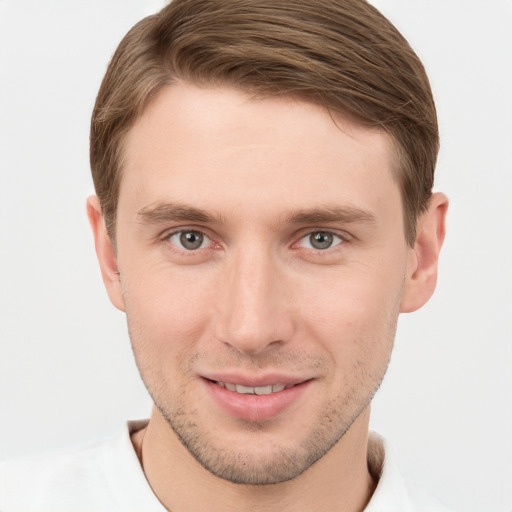 Joyful white young-adult male with short  brown hair and grey eyes