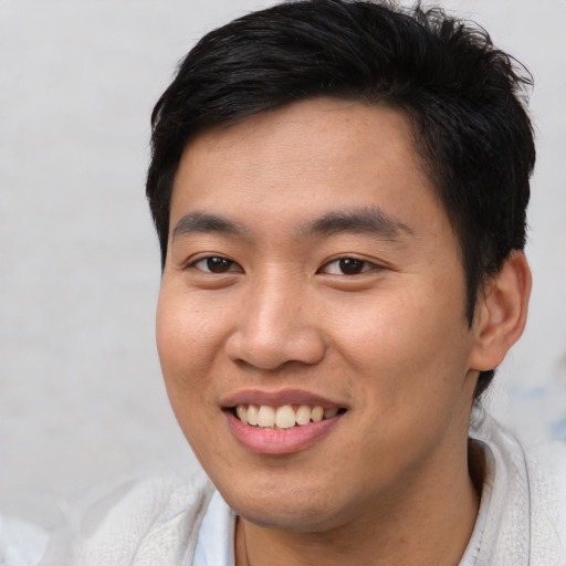 Joyful asian young-adult male with short  brown hair and brown eyes