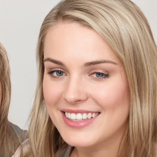 Joyful white young-adult female with long  brown hair and blue eyes