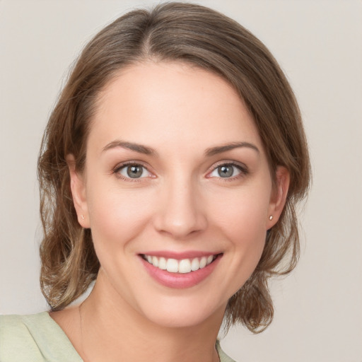 Joyful white young-adult female with medium  brown hair and green eyes