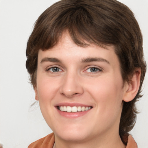 Joyful white young-adult female with medium  brown hair and green eyes