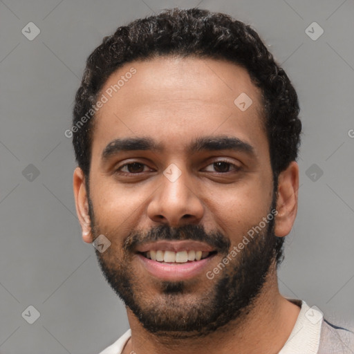 Joyful black young-adult male with short  black hair and brown eyes