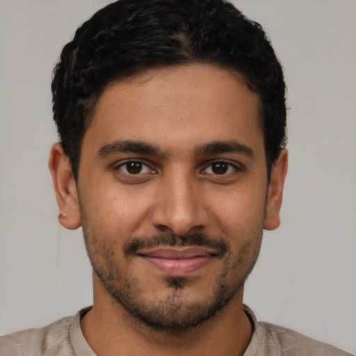 Joyful latino young-adult male with short  black hair and brown eyes